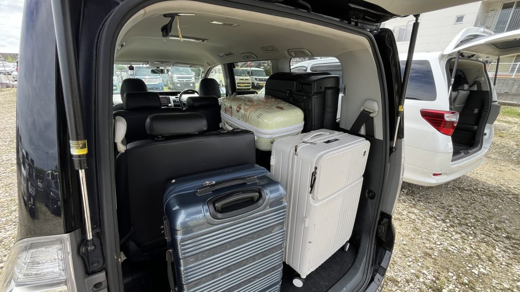 Toyota Voxy 트렁크 — 3열 반쯤 접은 상태, 대중소 캐리어 6개 적재