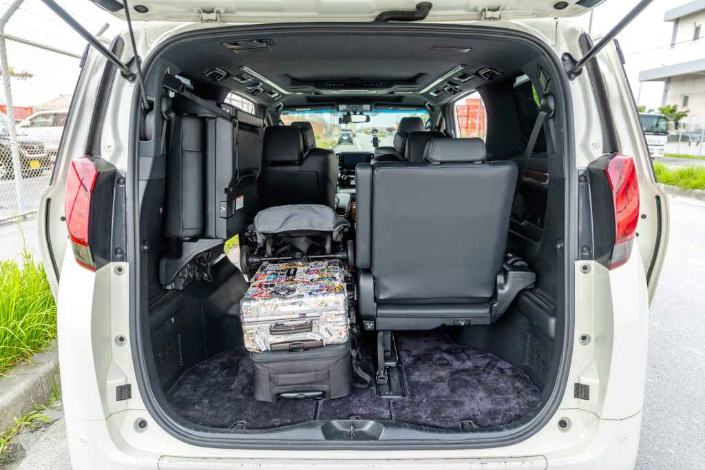 Toyota Alphard 트렁크 — 3열 시트 반쯤 접은 상태, 대형·중형·소형 다수 적재