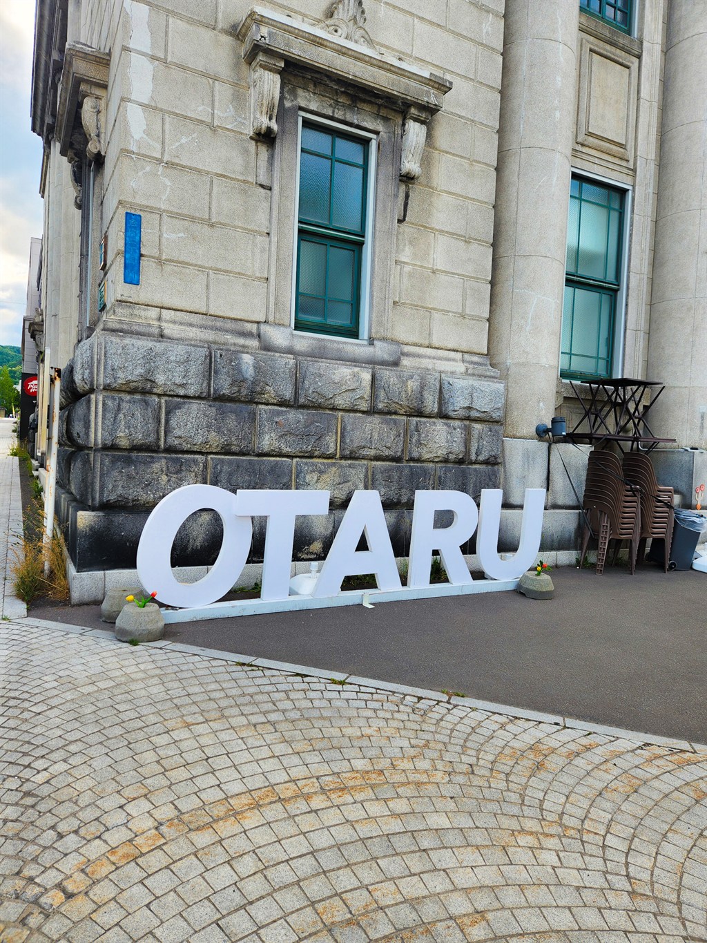 석조 건물 앞에 놓인 하얀 OTARU 레터 조형물