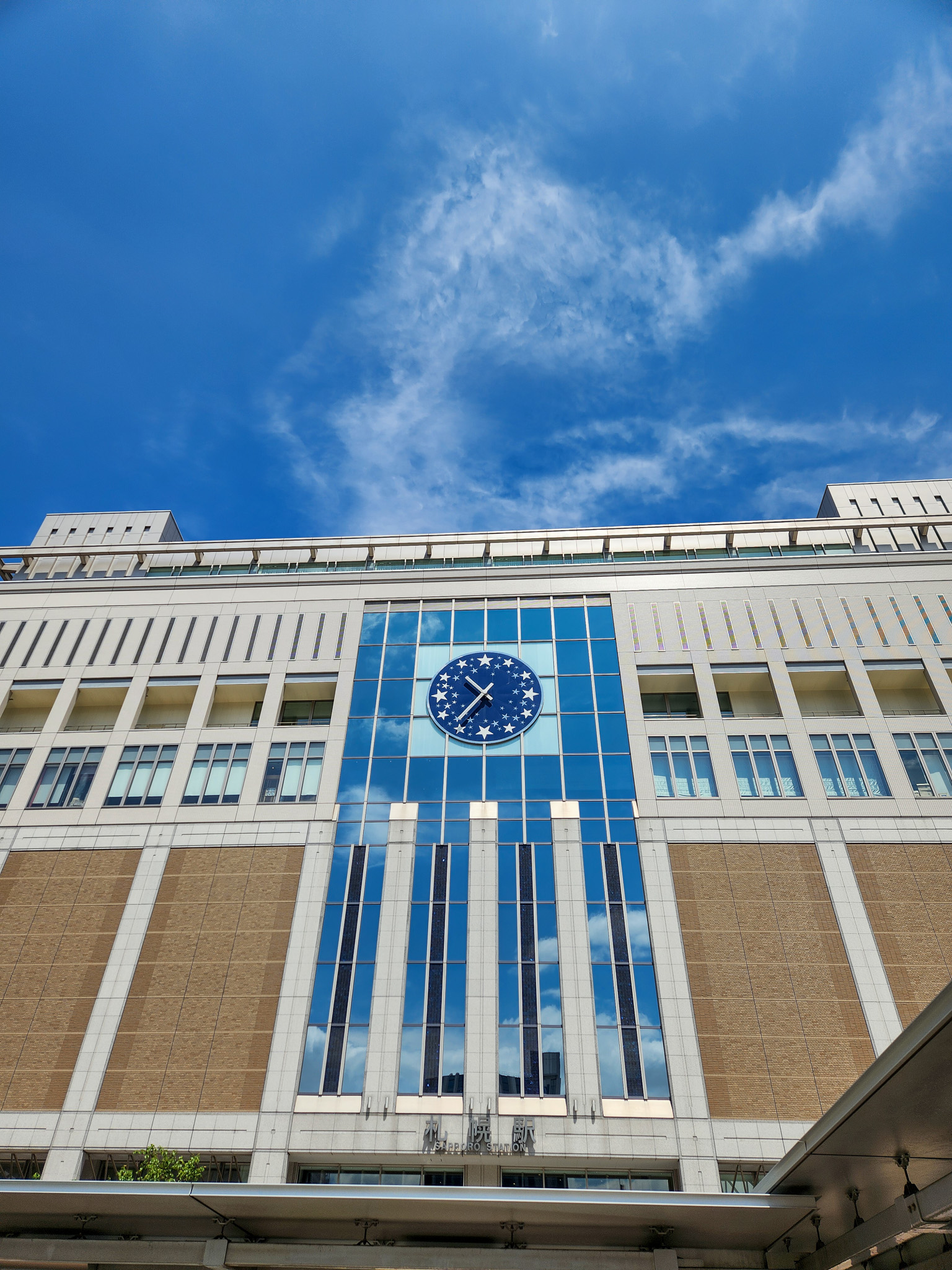 파란 하늘과 큰 시계가 인상적인 JR 삿포로역 역사 외관